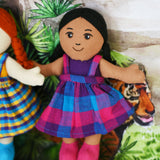 A A Lanka Kade Girl Doll with Brown Skin and Black Hair placed on a headboard, leaning against a wall.
