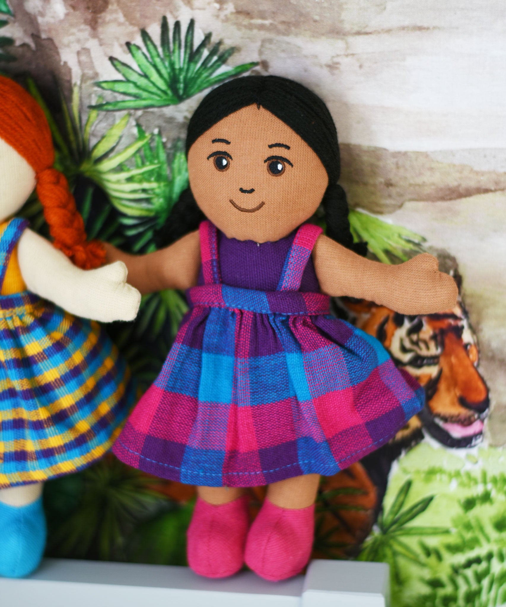 A A Lanka Kade Girl Doll with Brown Skin and Black Hair placed on a headboard, leaning against a wall.