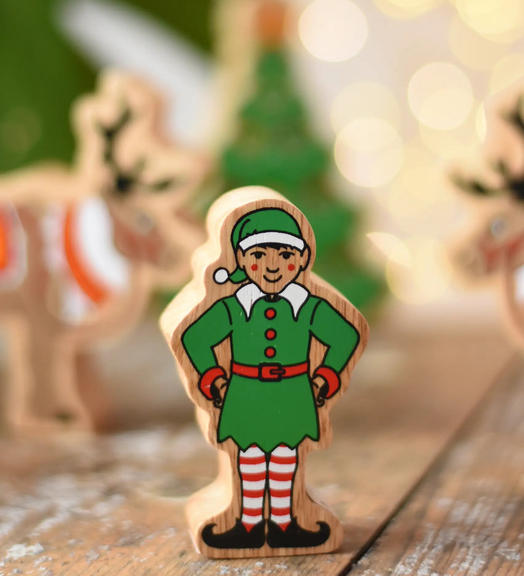 Lanka Kade Christmas elf wooden toy figure. Green outfit and hat with red and white striped leggings.