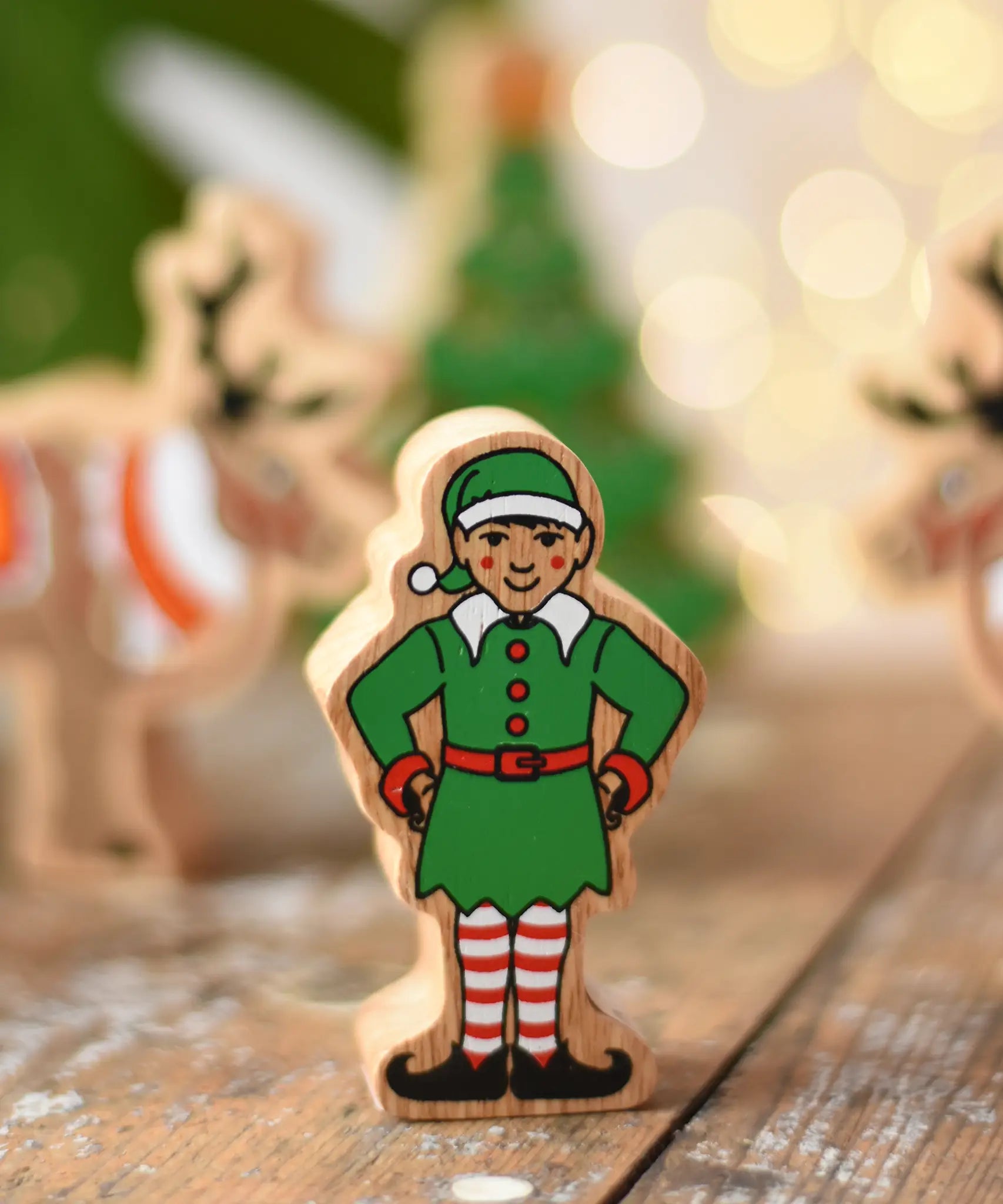 Lanka Kade Christmas elf wooden toy figure. Green outfit and hat with red and white striped leggings.