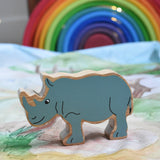 A Lanka Kade Grey Rhino Wooden Wild Animal Figure placed on a Wonderie Plains of Africa play cloth. A Grimm's rainbow can be seen in the background. These wooden toy figures are part of a huge range of Lanka Kade fair trade, wooden toys available here at Babipur.