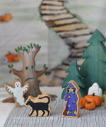 A Lanka Kade black cat and witch figures placed at the front of a small world play scene. 