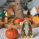A Lanka Kade Hermit wooden toy figure placed next to an Erzi pumpkin. 