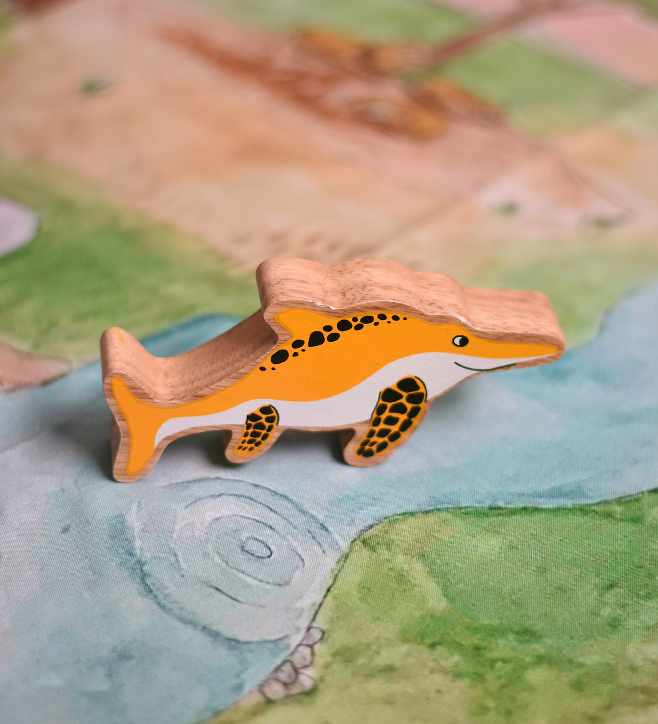 A Lanka Kade icthyosaur placed on a Wonderie play cloth. These wooden toy figures are part of a huge range of Lanka Kade fair trade, wooden toys available here at Babipur.