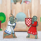 Lanka Kade wooden red foot knight standing next to a blue knight with raised sword figure in front of a wooden castle