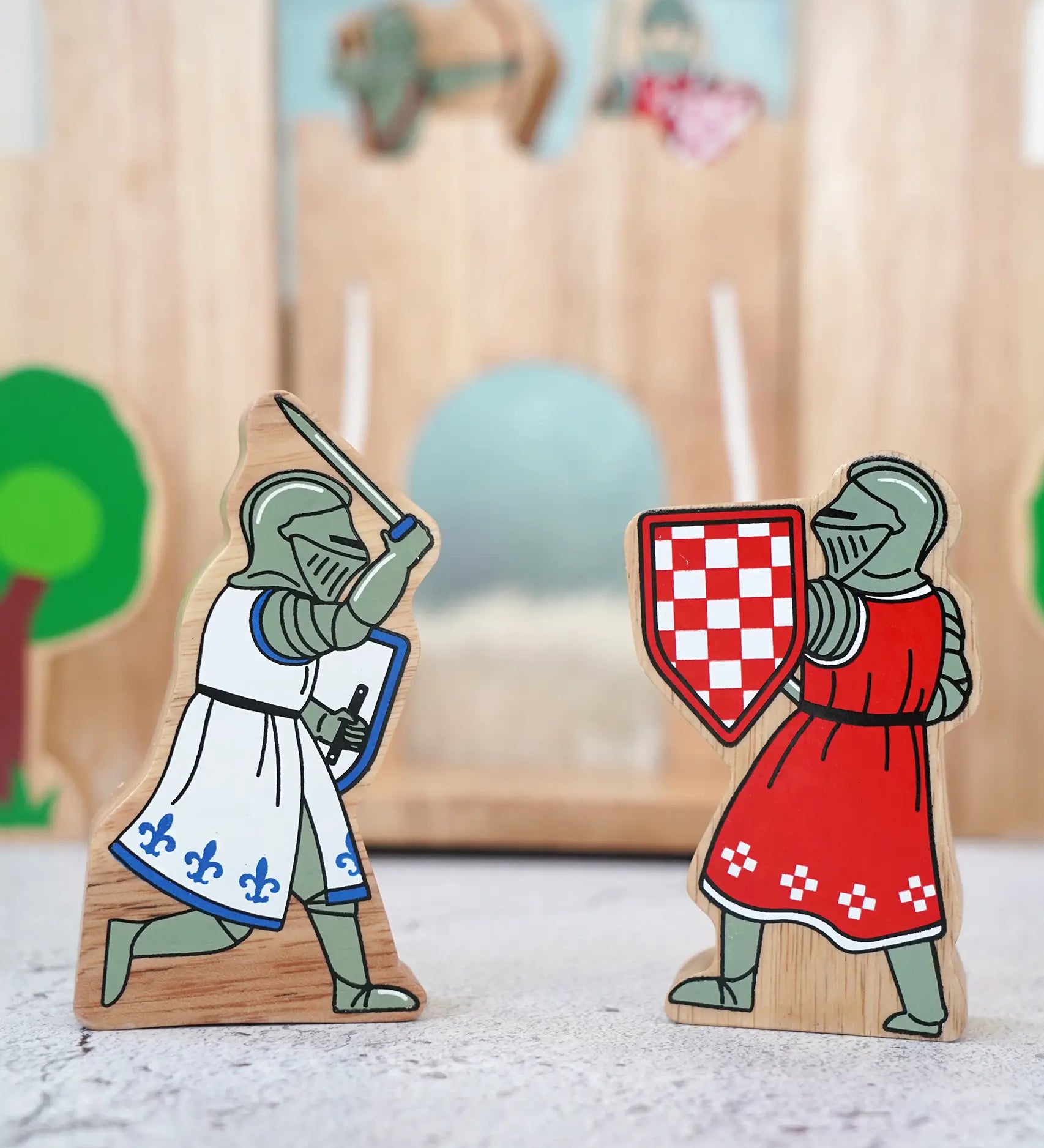 Lanka Kade wooden red foot knight standing next to a blue knight with raised sword figure in front of a wooden castle