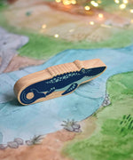 A Lanka Kade mosasurus wooden toy figure placed on a Wonderie plains of Africa play cloth. These wooden toy figures are part of a huge range of Lanka Kade fair trade, wooden toys available here at Babipur.
