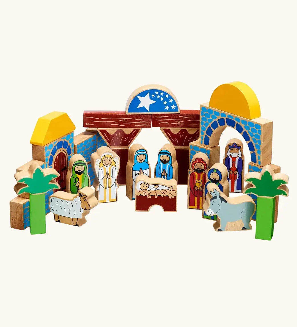 A wooden toy Lanka Kade nativity featuring painted blocks, arches, stable, palm trees, animals, and figures representing the Holy Family, Wise Men, and shepherds.