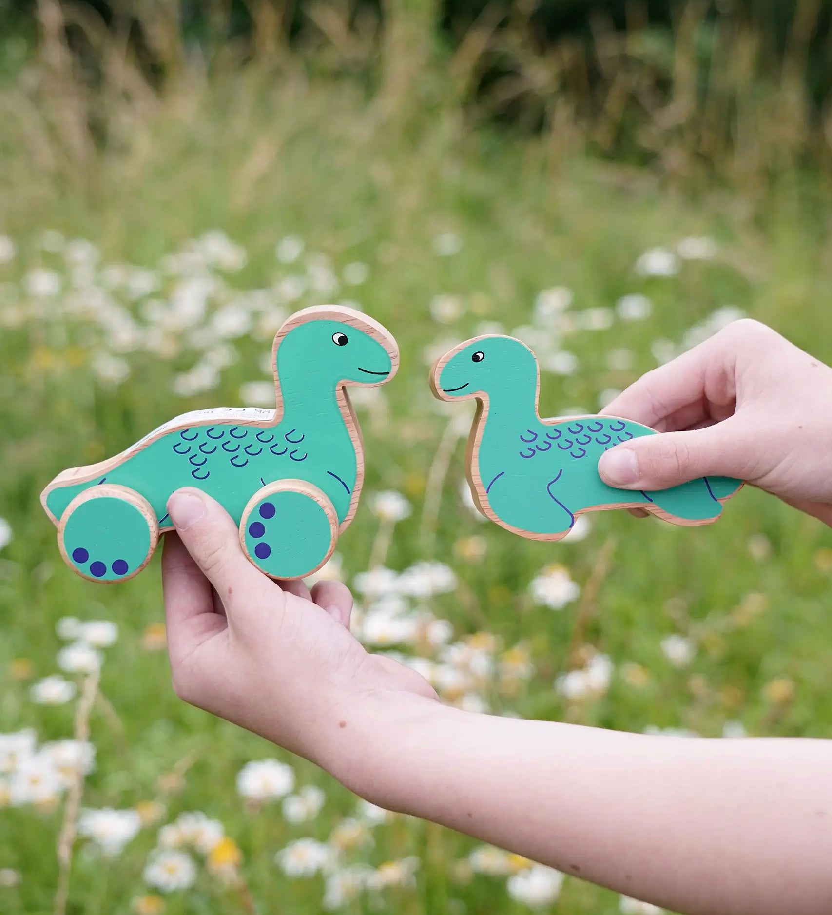 Lanka Kade Nessie push-along and Nessie wooden toy figure in a child's hands.