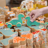 Lanka Kade Nessie push-along and Nessie wooden toy figure placed on stacks of other Lanka Kade animal figures.