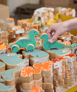 Lanka Kade Nessie push-along and Nessie wooden toy figure placed on stacks of other Lanka Kade animal figures.