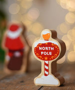 Lanka Kade North Pole sign wooden toy figure. Red snow toped sign with yellow top and striped pole.