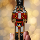 Lanka Kade nutcracker Christmas wooden toy figure in an adult's hand.