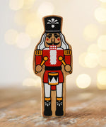 Lanka Kade nutcracker Christmas wooden toy figure placed on a wooden surface in the Babipur playroom.