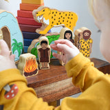 A child playing with the Lanka Kade Prehistoric Playset. A play set that contains 8 wooden figure and scenery pieces. These wooden toy figures are part of a huge range of Lanka Kade fair trade, wooden toys available here at Babipur.