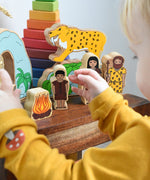 A child playing with the Lanka Kade Prehistoric Playset. A play set that contains 8 wooden figure and scenery pieces. These wooden toy figures are part of a huge range of Lanka Kade fair trade, wooden toys available here at Babipur.