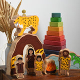 The Lanka Kade Prehistoric Playset set up on a small wooden table, a Grimm's Wankel stacking toy can be seen in the background. A play set that contains 8 wooden figure and scenery pieces. These wooden toy figures are part of a huge range of Lanka Kade fair trade, wooden toys available here at Babipur.