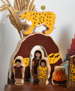 The Lanka Kade Prehistoric Playset set up on a small wooden table. A play set that contains 8 wooden figure and scenery pieces. These wooden toy figures are part of a huge range of Lanka Kade fair trade, wooden toys available here at Babipur.