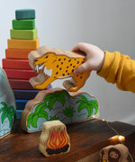 A child playing with the sabre tooth tiger from the Lanka Kade Prehistoric Playset. A play set that contains 8 wooden figure and scenery pieces. These wooden toy figures are part of a huge range of Lanka Kade fair trade, wooden toys available here at Babipur.