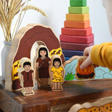 A child holding the fire from the Lanka Kade Prehistoric Playset. A play set that contains 8 wooden figure and scenery pieces. These wooden toy figures are part of a huge range of Lanka Kade fair trade, wooden toys available here at Babipur.
