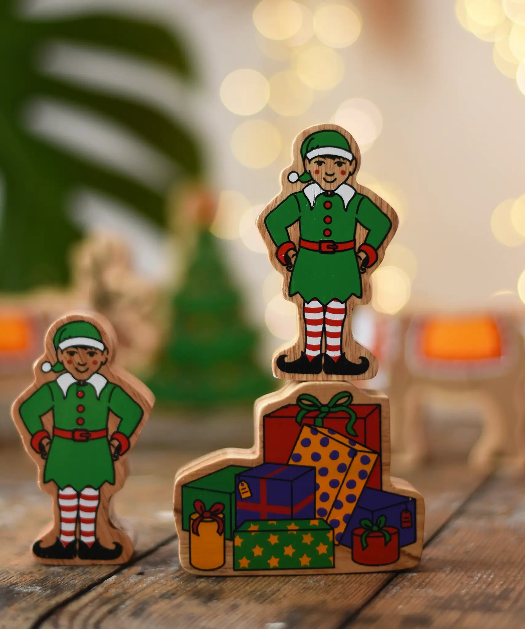 Lanka Kade Christmas presents wooden toy figure with an elf figure standing on top placed on a wooden surface in the Babipur playroom.