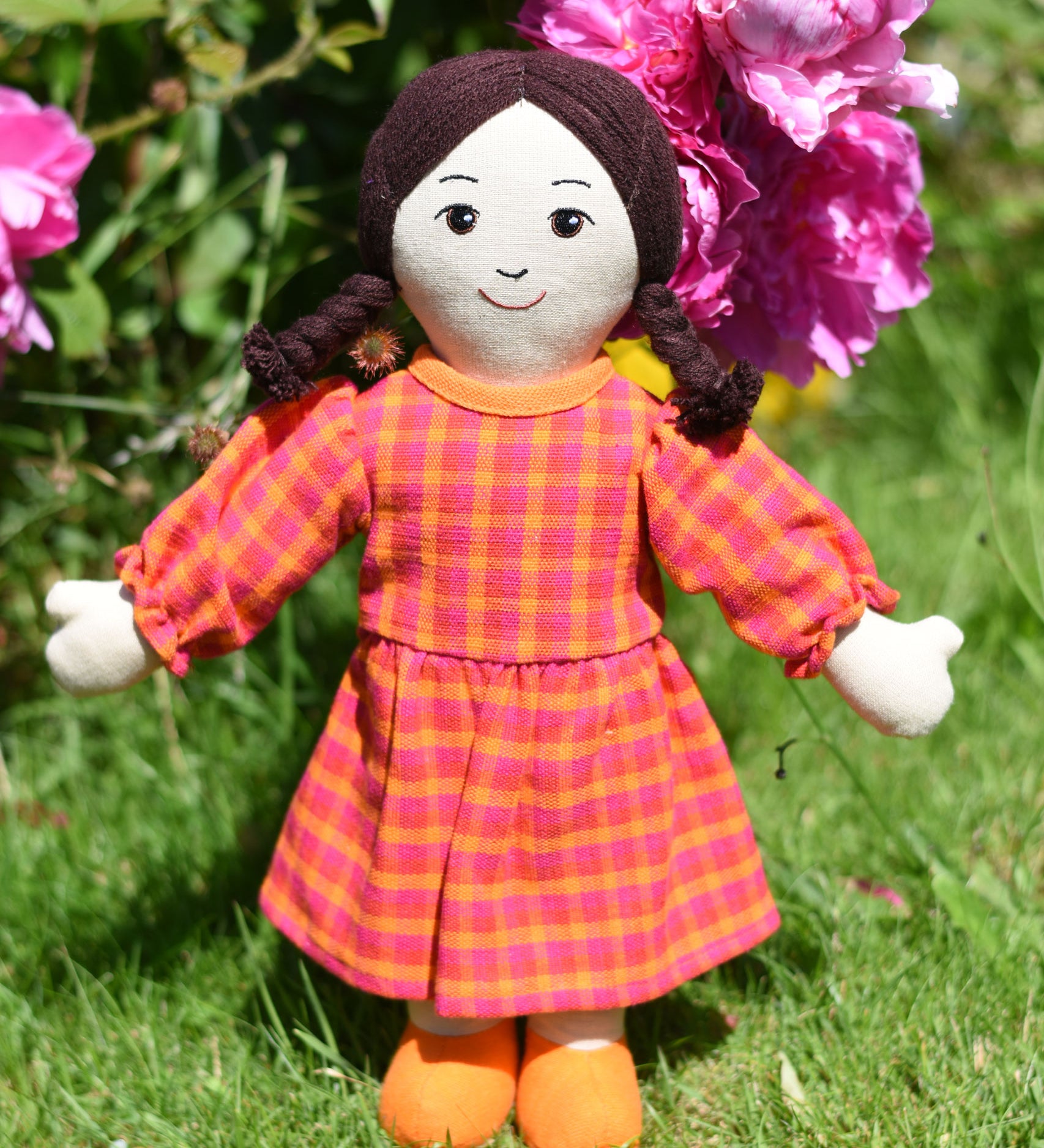 A Lanka Kade Rag Doll Mum with White Skin and Black Hair placed on grass outdoors.