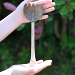 A coconut shell rake shown in a child's hand. These coconut shell utensils are a welcome addition to our range of outdoor toys here at Babipur. 