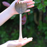 A coconut shell rake shown in a child's hand. These coconut shell utensils are a welcome addition to our range of outdoor toys here at Babipur. 