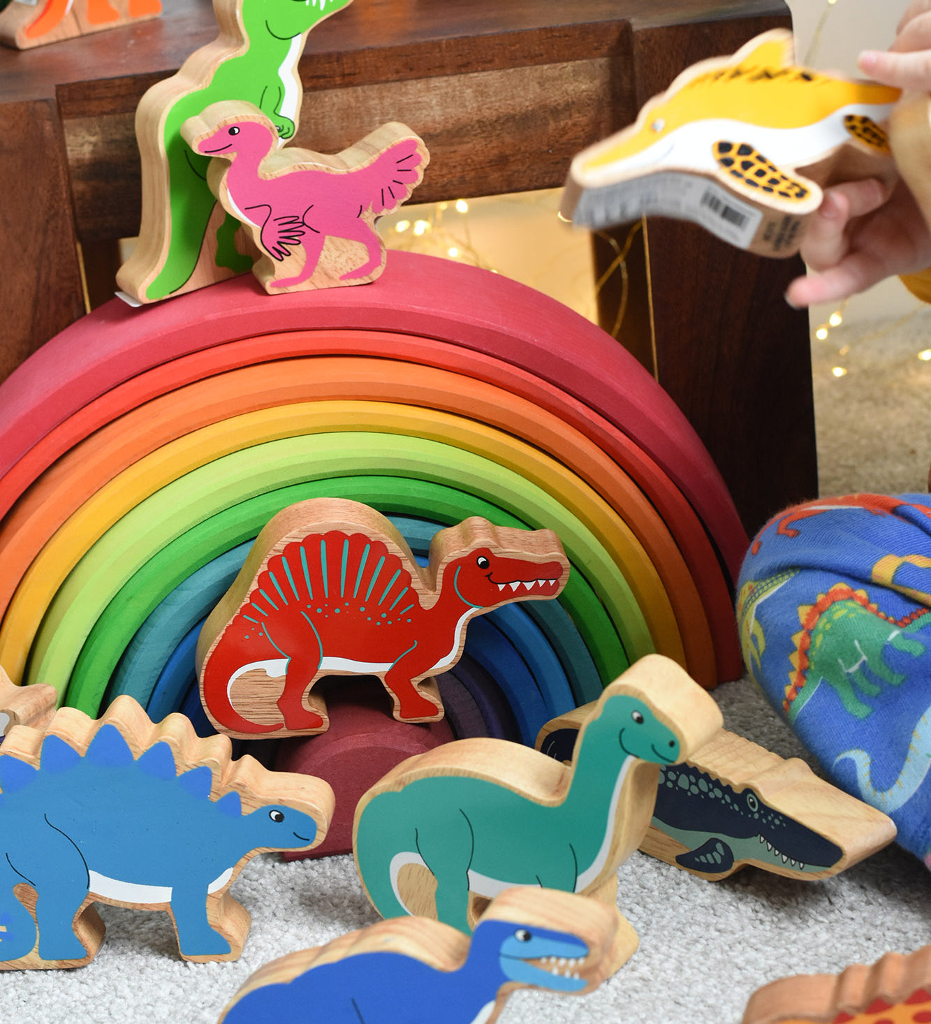 A child playing with the Lanka Kade wooden dinosaur figures. These wooden toy figures are part of a huge range of Lanka Kade fair trade, wooden toys available here at Babipur.
