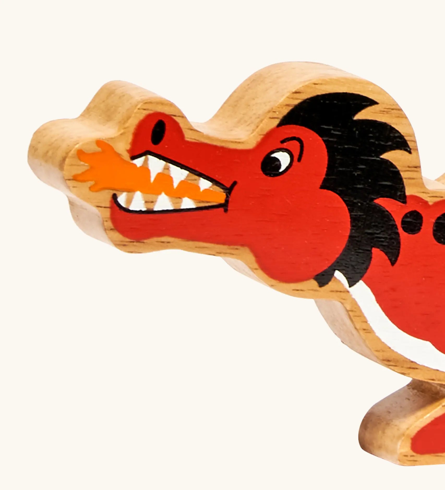Close-up of the Lanka Kade wooden toy dragon in red showing painted facial features, orange mouth flame.