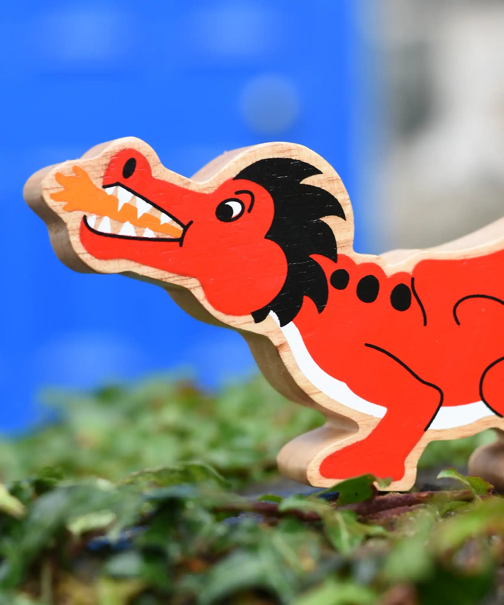 Lanka Kade red dragon wooden toy dragon figure with black details, close up of the dragon's face.