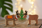 Lanka Kade reindeer wooden toy figures. One has red reigns. 