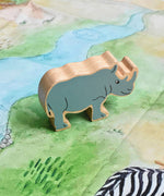 A Lanka Kade Grey Rhino Wooden Wild Animal Figure placed on a Wonderie Plains of Africa play cloth. These wooden toy figures are part of a huge range of Lanka Kade fair trade, wooden toys available here at Babipur.