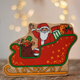 Lanka Kade Father Christmas in a sleigh wooden toy figure. The front features Santa sitting in the sleigh waving, surrounded by gifts. 