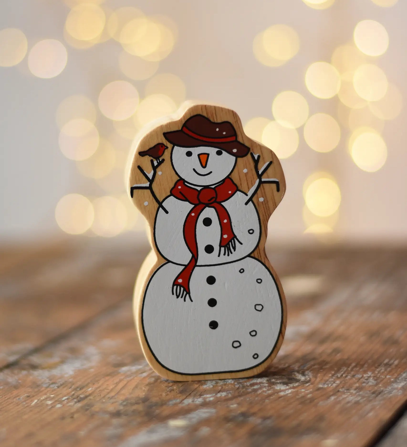 Lanka Kade Snowman Christmas wooden toy figure placed on a wooden surface in the Babipur playroom.