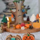 A Lanka Kade spider and pumpkin wooden toy figure placed in front of an Autumnal themed celebration ring set up.