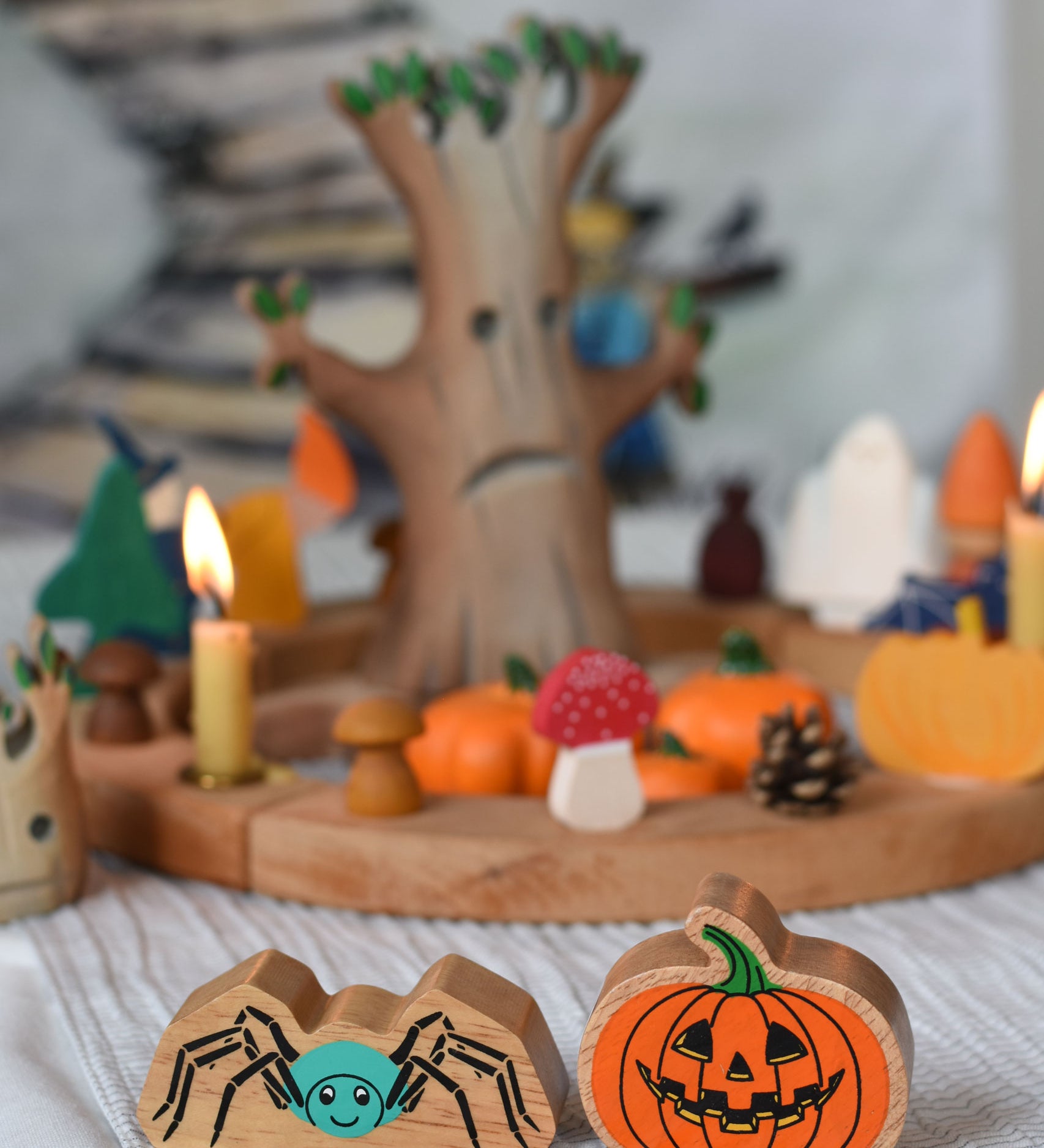 A Lanka Kade spider and pumpkin wooden toy figure placed in front of an Autumnal themed celebration ring set up.