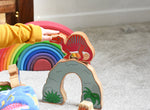 A child pointing at  the Lanka Kade Wooden Spinosaurus Dinosaur. These wooden toy figures are part of a huge range of Lanka Kade fair trade, wooden toys available here at Babipur.
