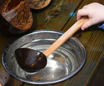 A close up of a Lanka Kade ladle spoon utensil being used in water.
