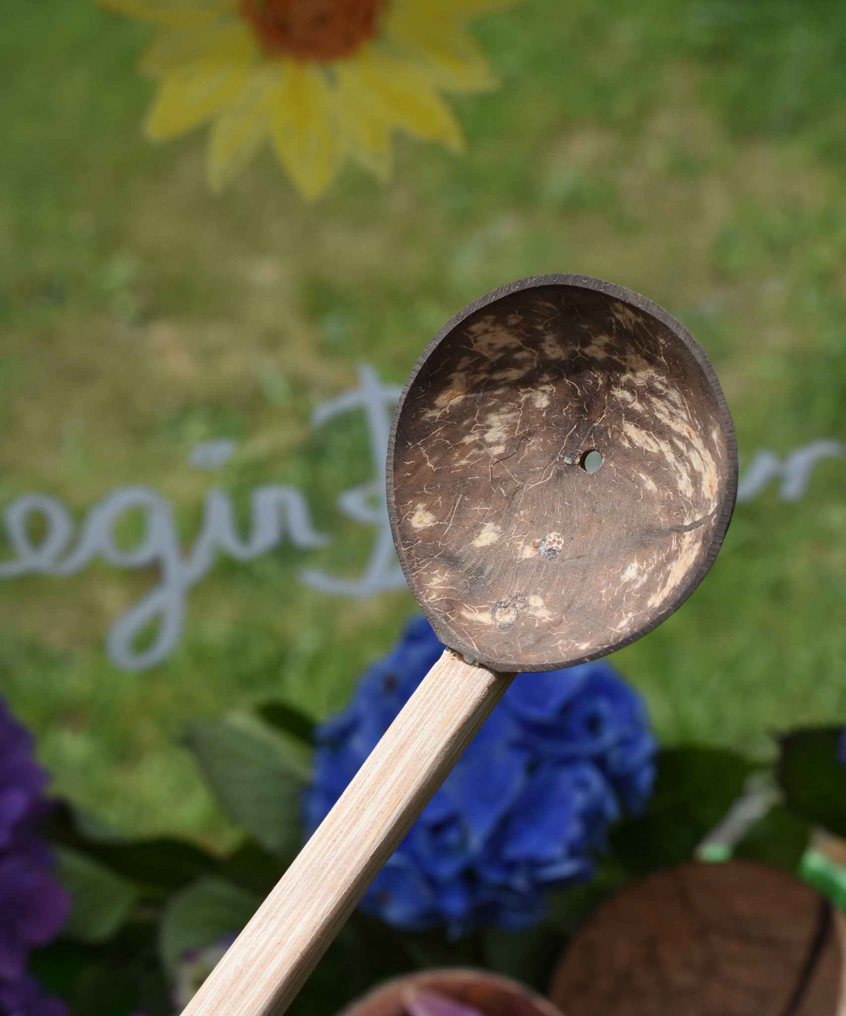 A close up of the coconut shell spoon with one hole from the utensil playset from Lanka Kade.