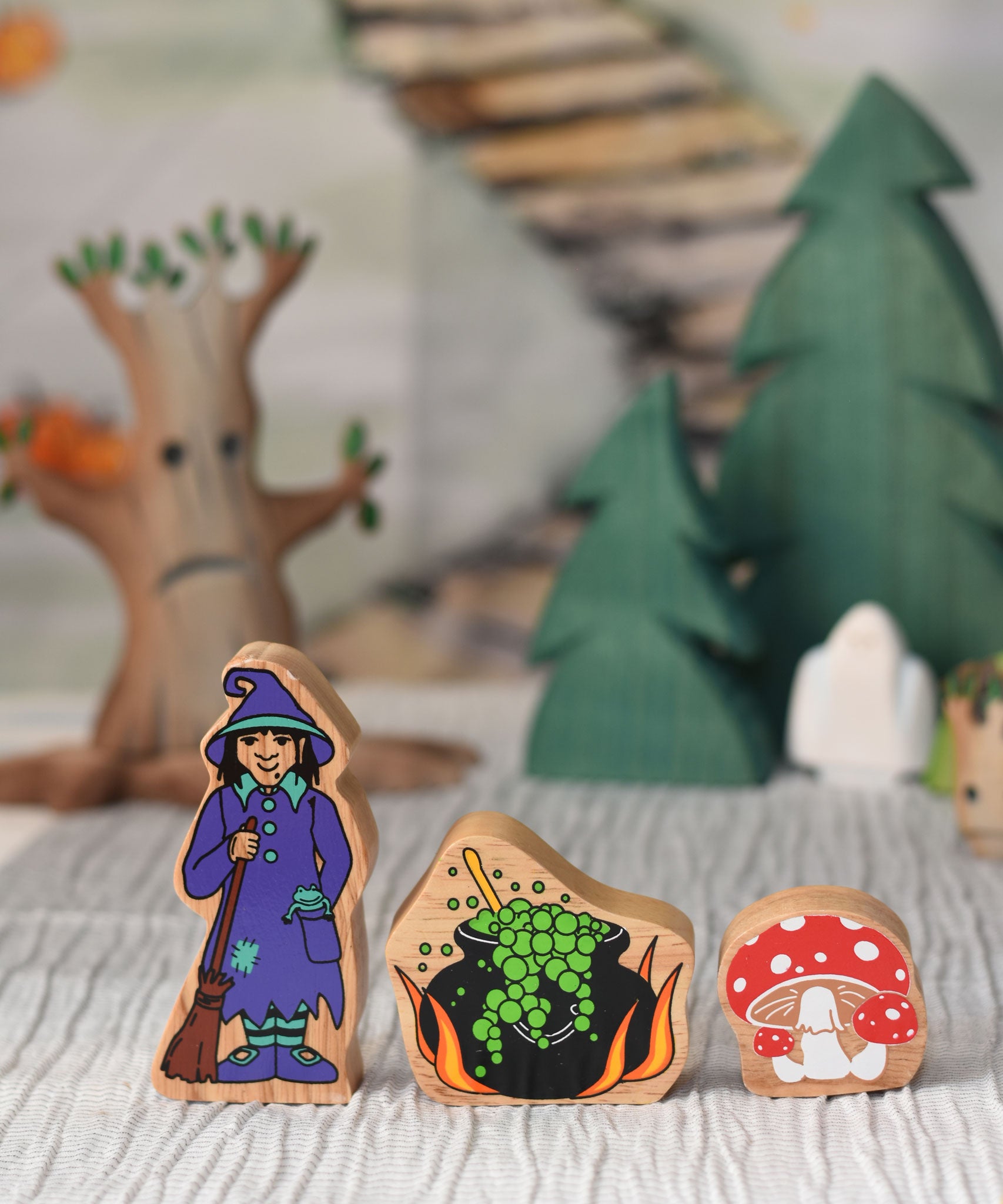 Lanka Kade witch, cauldron and toadstool figures placed at the front of a small world play scene. 
