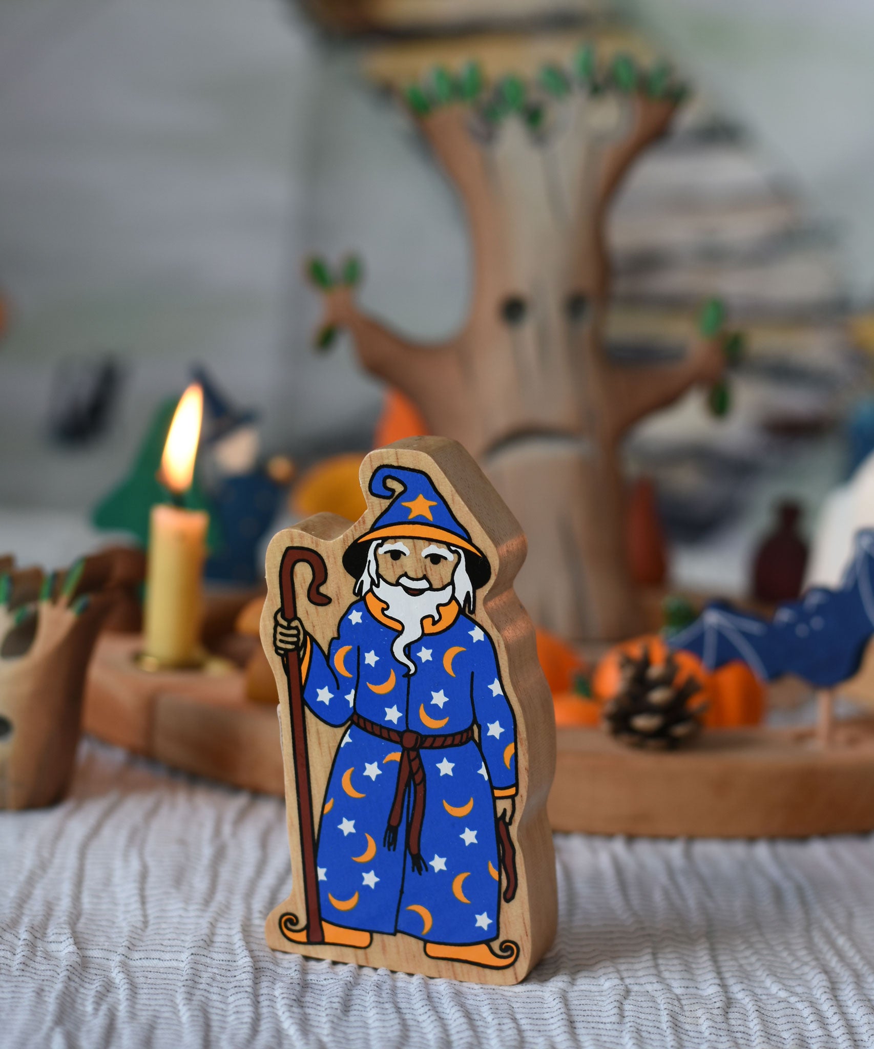 A Lanka Kade Wizard placed on a striped tablecloth with a Halloween themed Grimm's celebration ring set up in the background. 