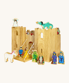 Lanka Kade wooden castle set with 12 wooden figures including a fairy, king and queen, dragon, knight, wizard, witch, gremlin, troll, prince and princess and a unicorn figure. Castle features 2 walls and a drawbridge with a lowering gate