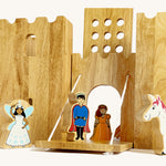 A close up of the drawbridge lowered and the gate lifted from the Lanka Kade wooden castle set showing the prince, princess fairy and unicorn figure in a fairytale setup.