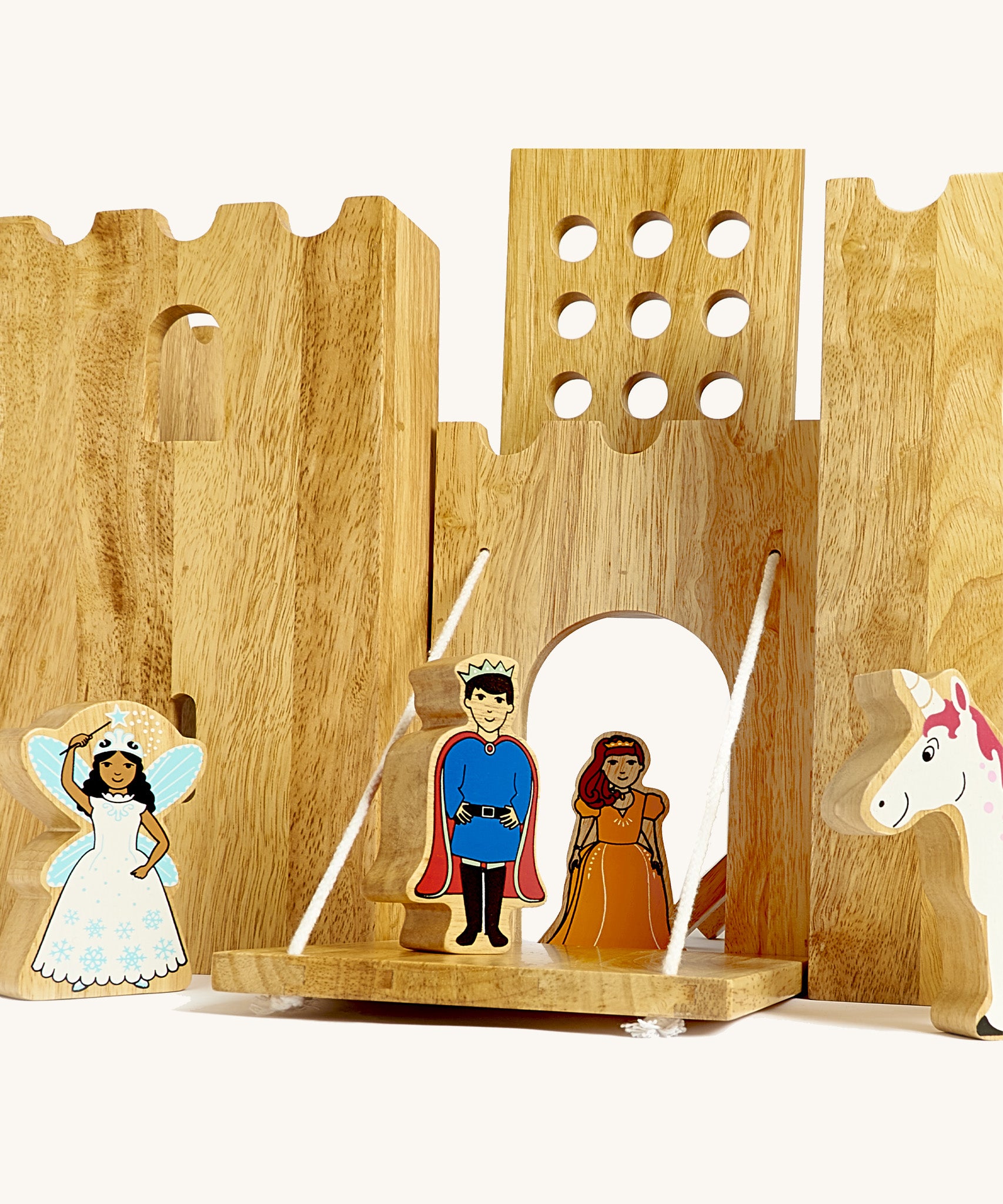 A close up of the drawbridge lowered and the gate lifted from the Lanka Kade wooden castle set showing the prince, princess fairy and unicorn figure in a fairytale setup.