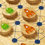 A close up of the Lanka Kade cosmic wooden board game showing the orange rocket ship and alien design on the circular counters and board detail
