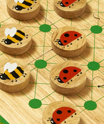 A close up of the Lanka Kade minibeast wooden board game showing the mini beast design on the circular counters and board detail