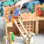 A Lanka Kade wooden toy castle with fairytale themed character figures placed in and around the castle.