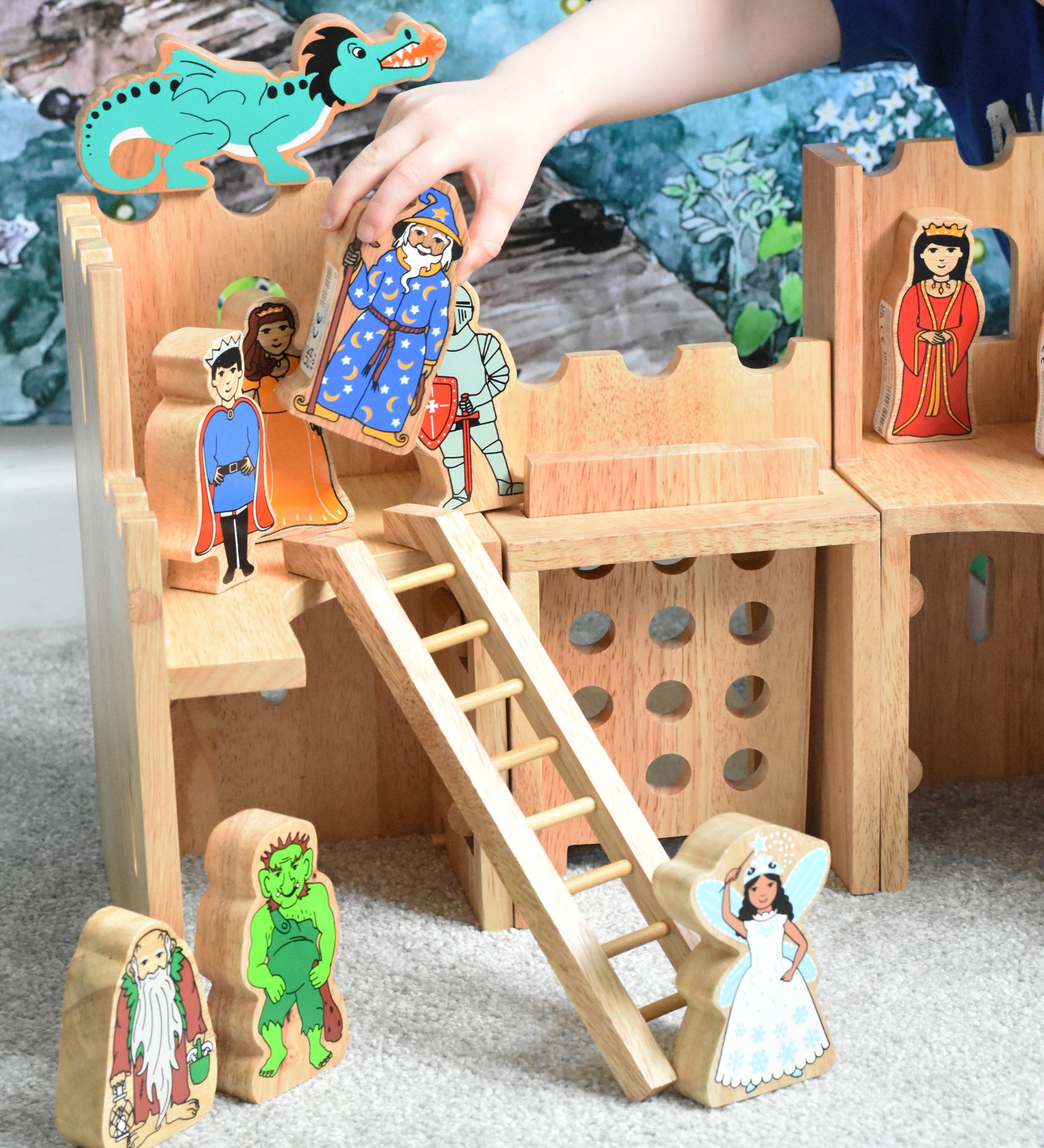 A Lanka Kade wooden toy castle with fairytale themed character figures placed in and around the castle.