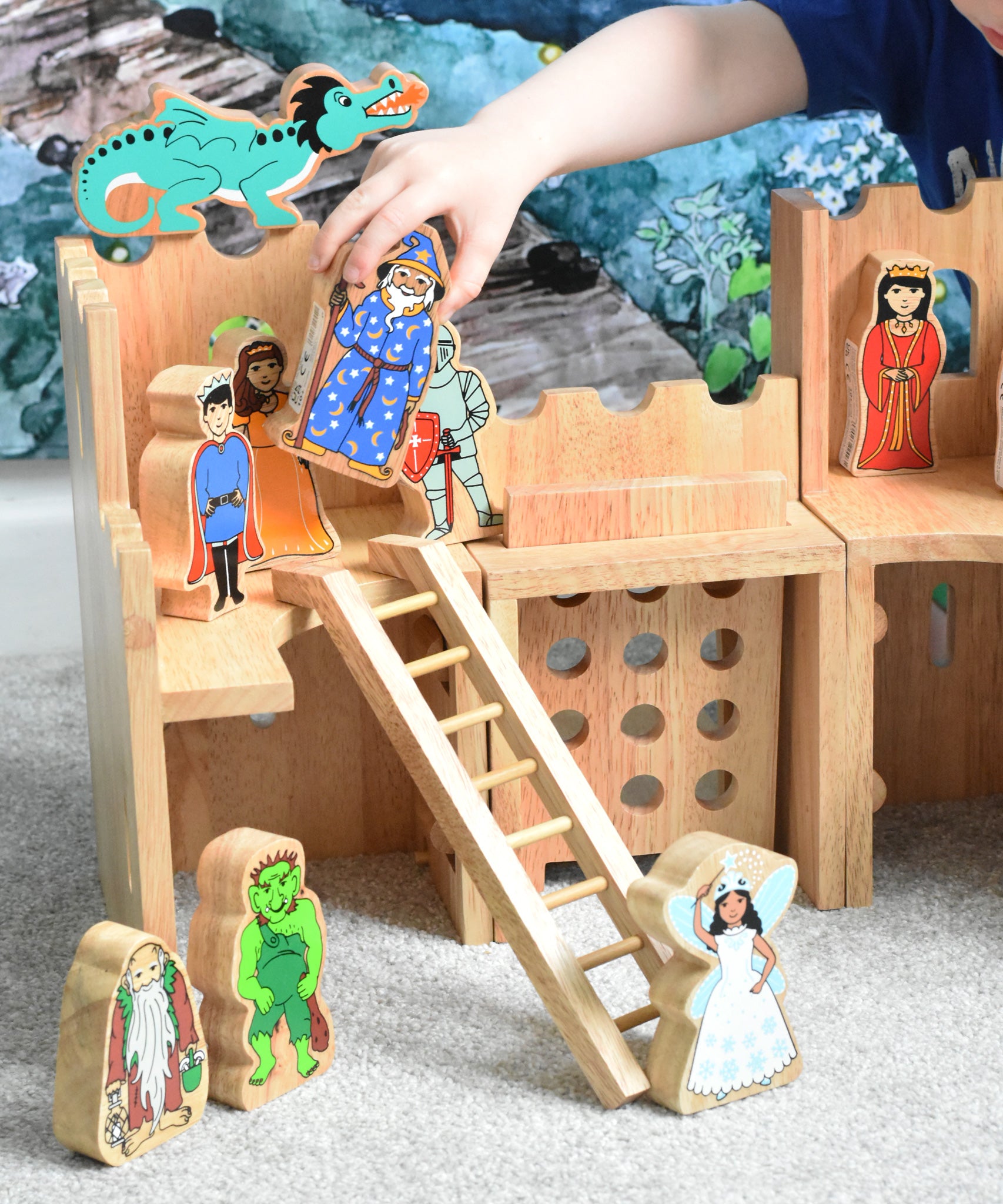 A Lanka Kade wooden toy castle with fairytale themed character figures placed in and around the castle.
